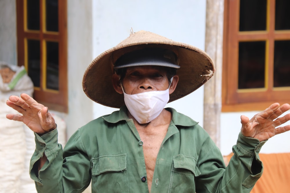 man in green button up shirt wearing white mask