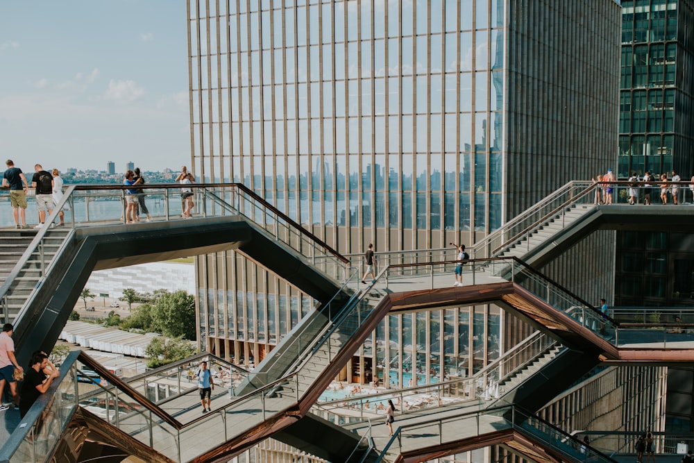 people walking on stairs near glass building during daytime