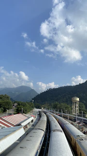 Wide exterior view of the Xiaoxiang train parked at a picturesque rural station under clear skies