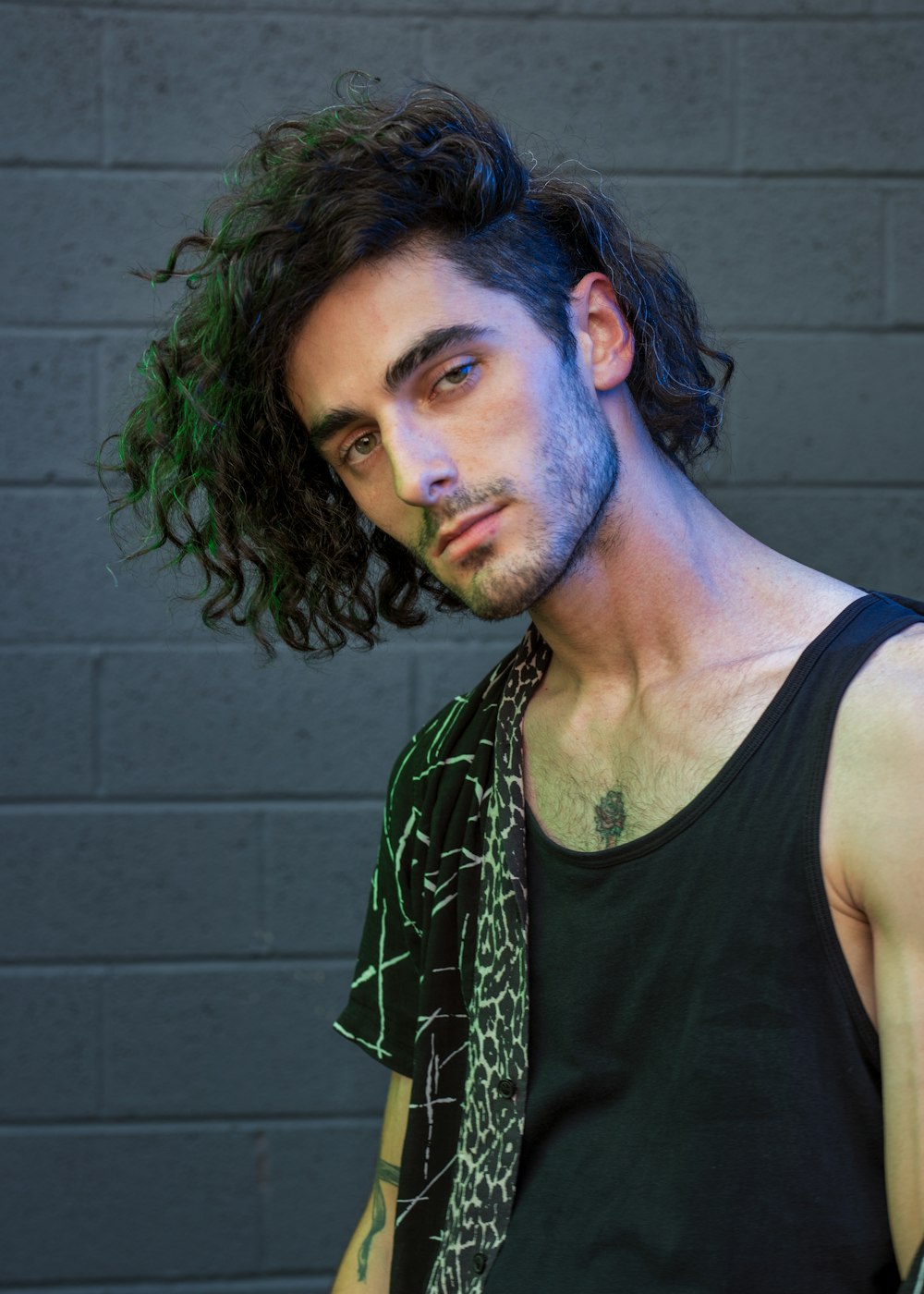 man in black tank top with green and white scarf