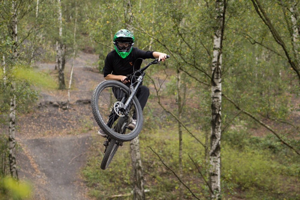 man in black jacket riding bicycle on dirt road during daytime