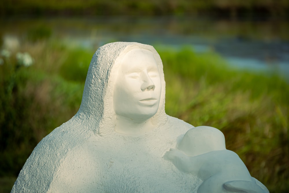 white ceramic angel figurine on green grass field during daytime