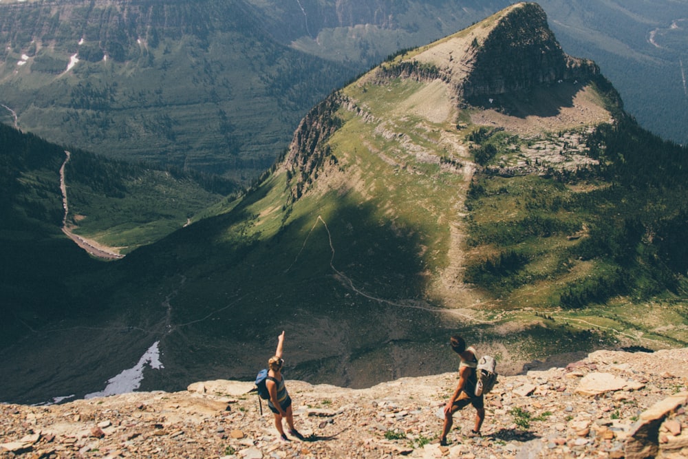 2 women standing on rocky mountain during daytime