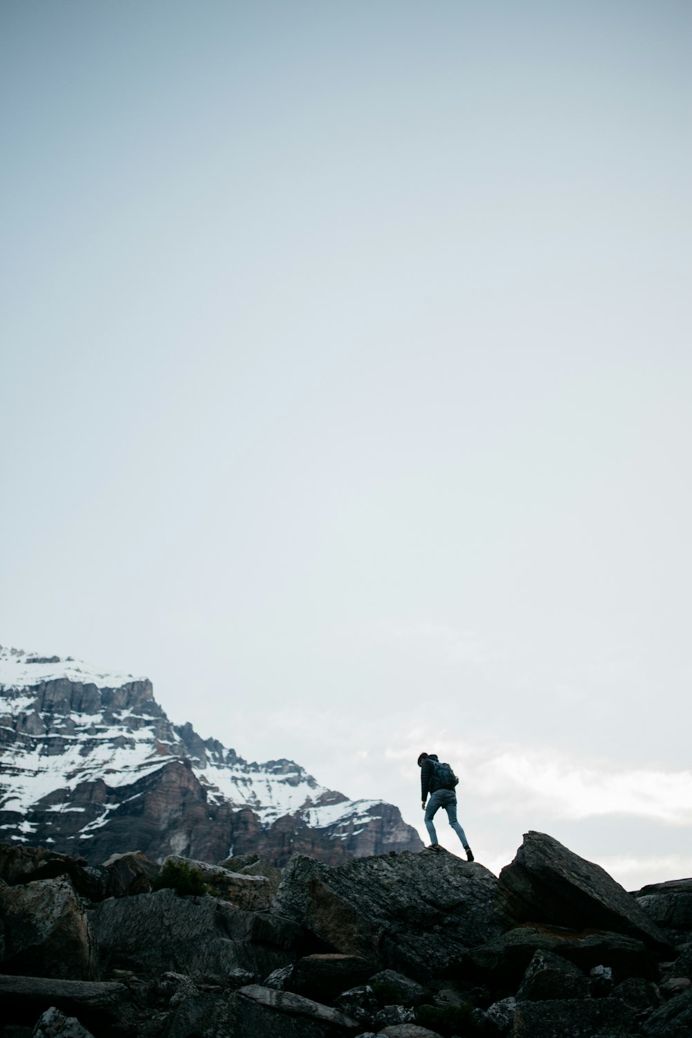 man in black jacket standing on rock formation during daytime