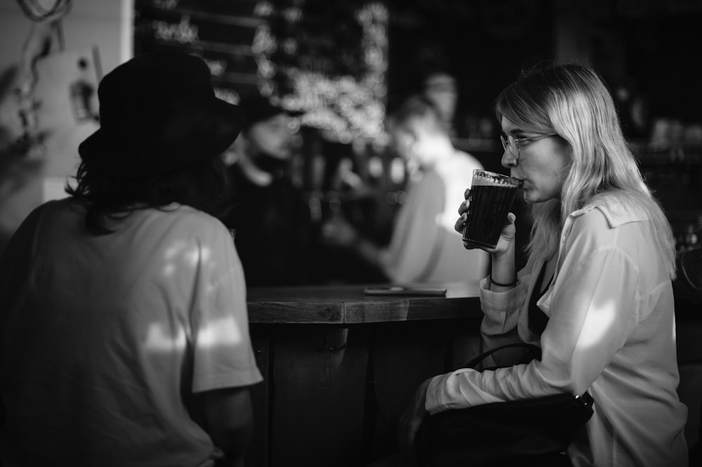 grayscale photo of woman drinking from cup