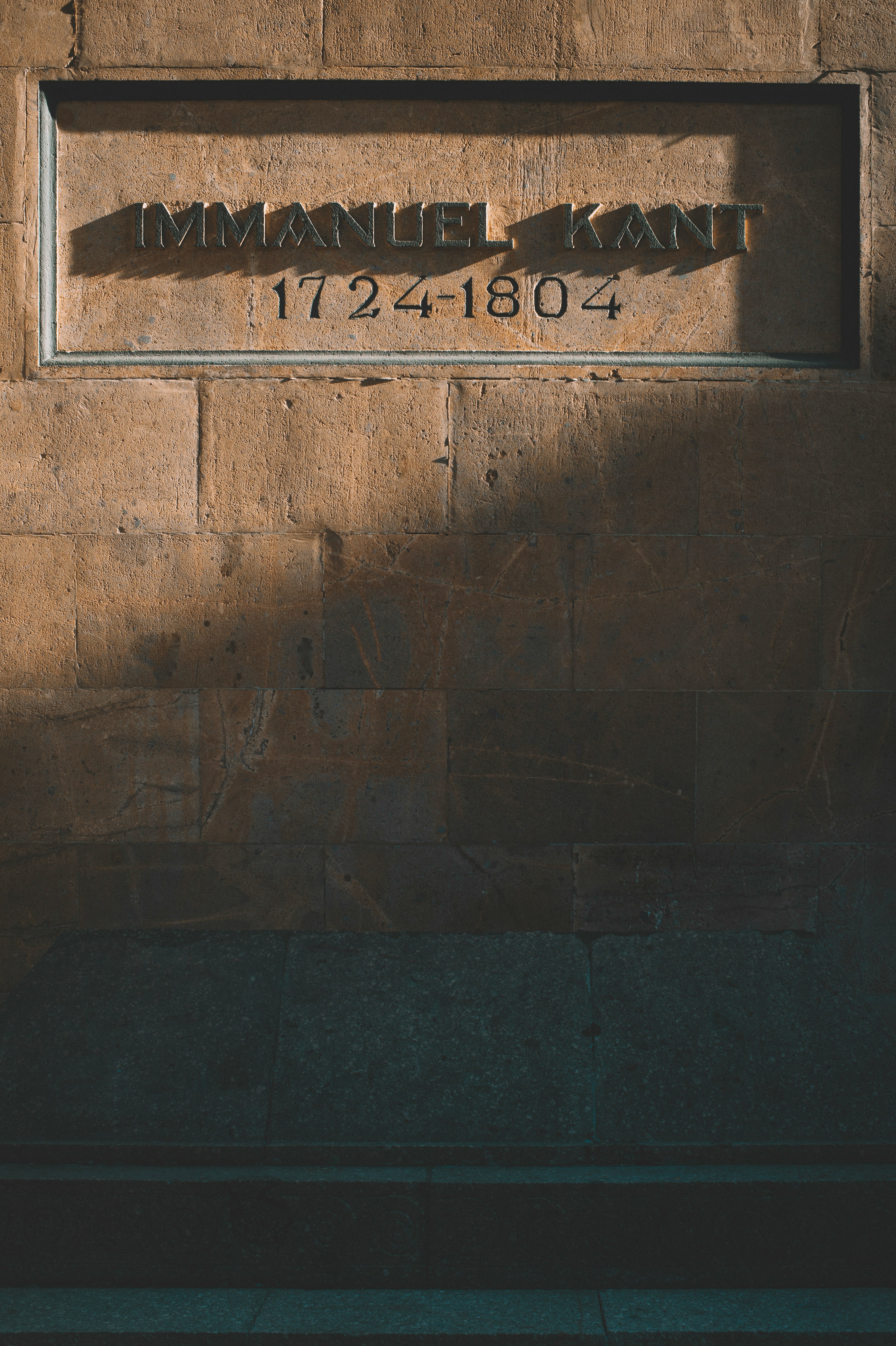 brown brick wall with welcome to the beach signage