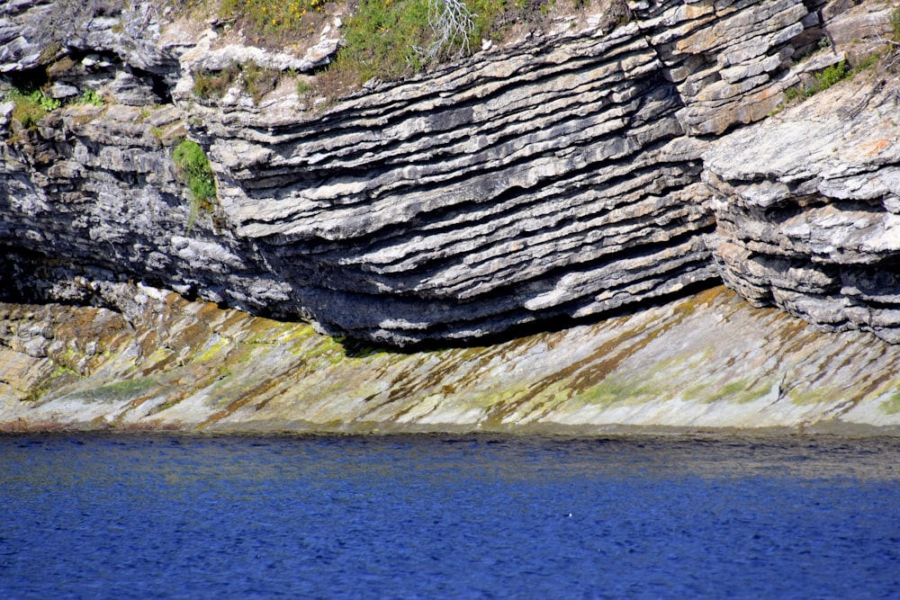 gray rock formation near body of water during daytime