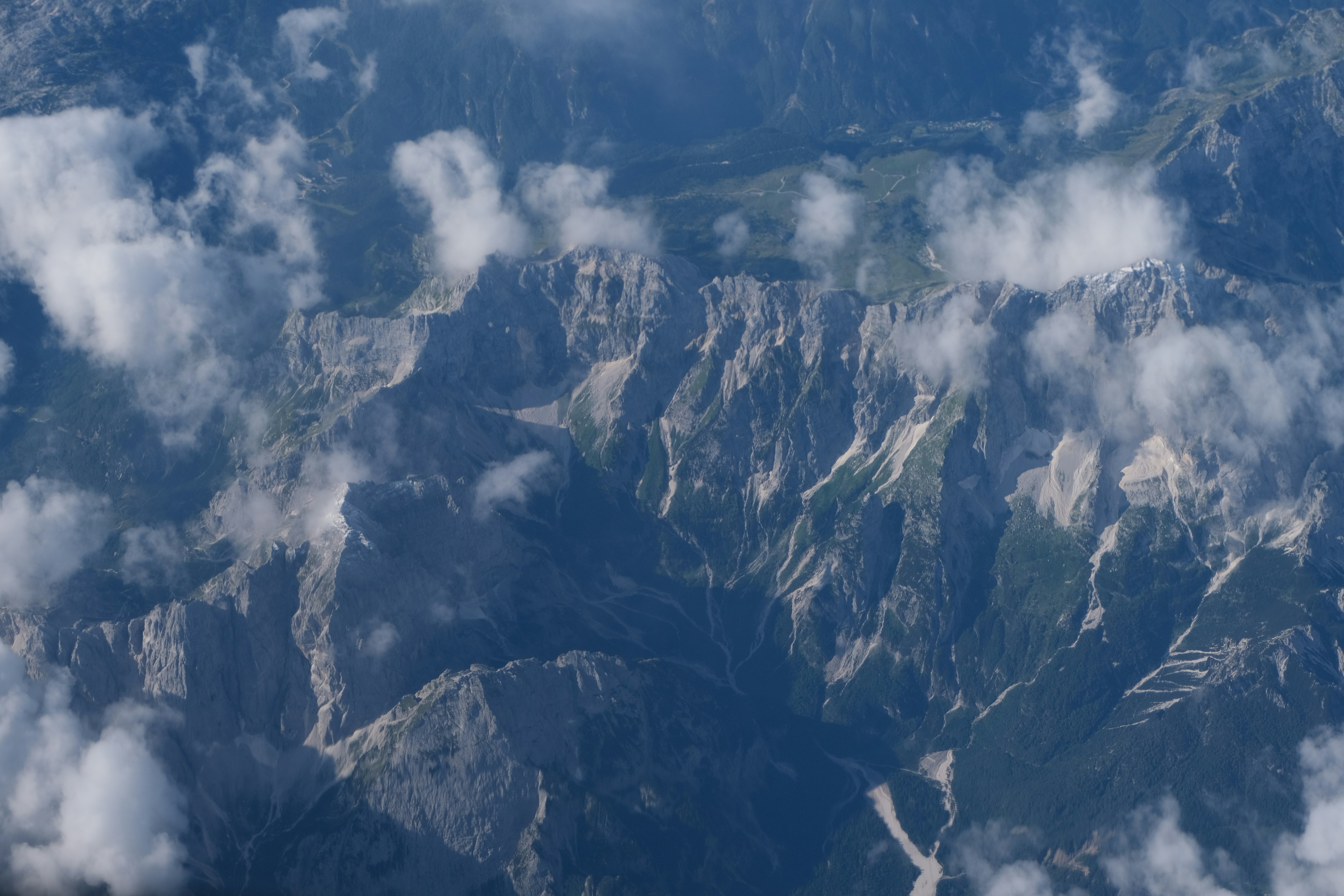 montagne bianche e nere sotto nuvole bianche e cielo blu durante il giorno