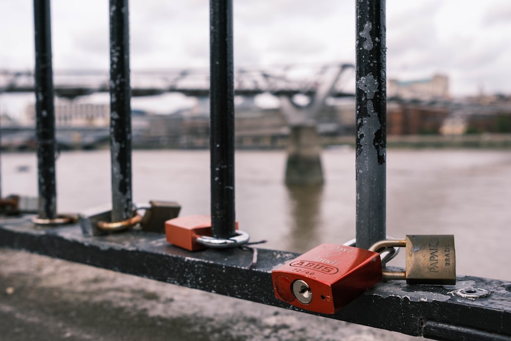 red and brown padlock on black metal bar