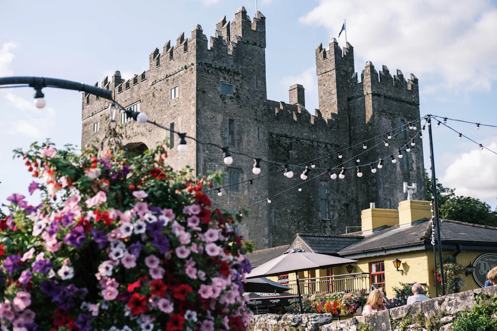 Zamek Bunratty i kwiaty przed pubem Durty Nelly's w Bunratty, kilka km od Shannon