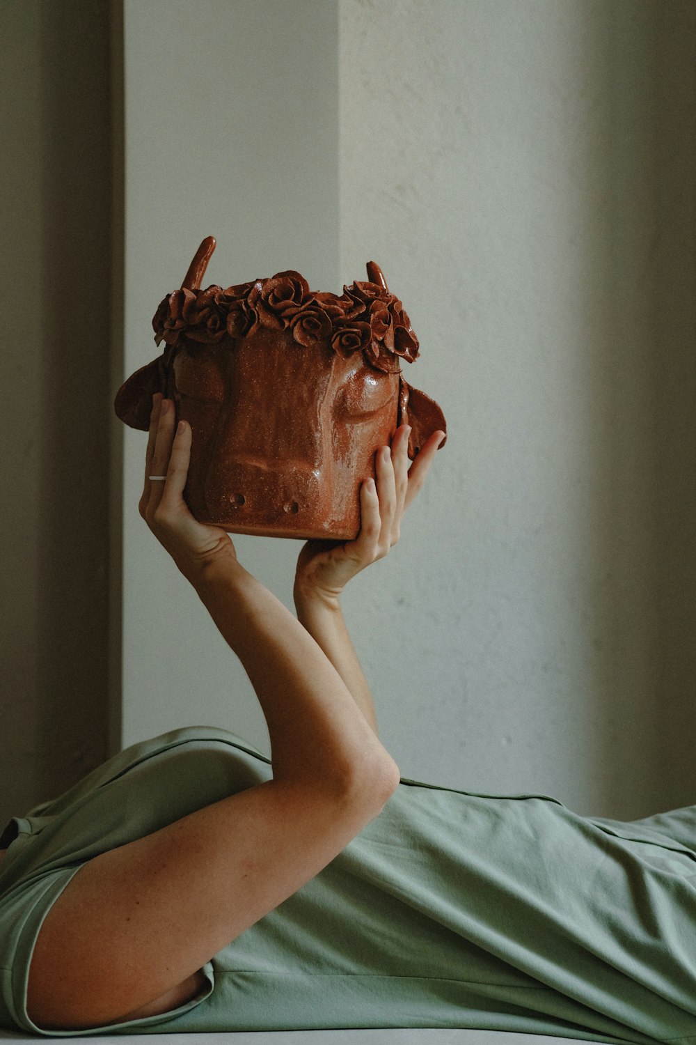 person holding brown ceramic pot