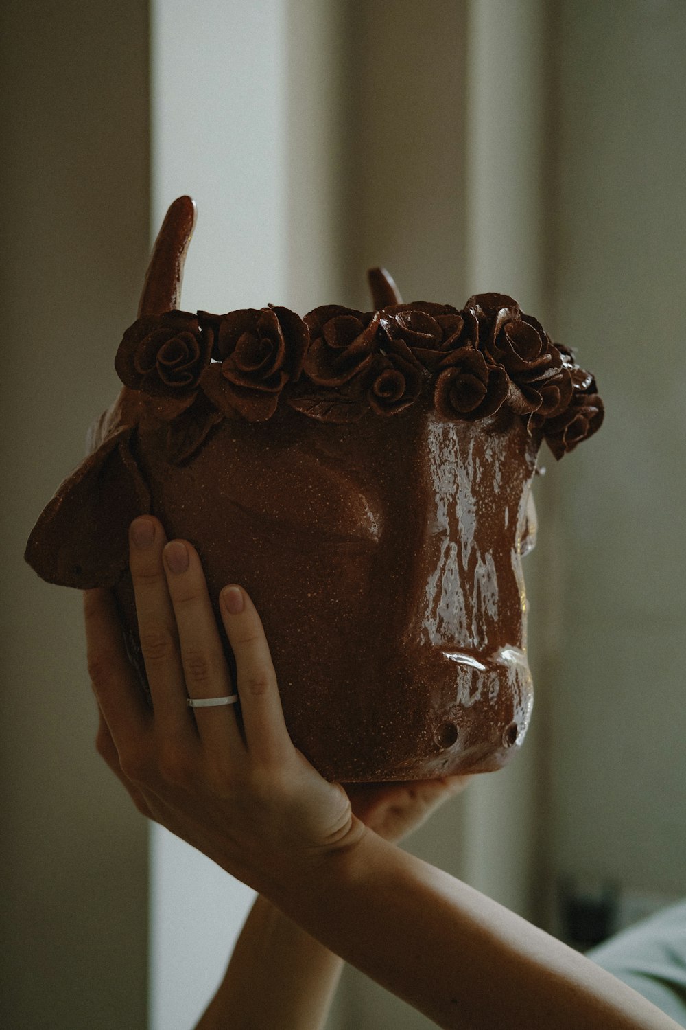 person holding chocolate cake on white table