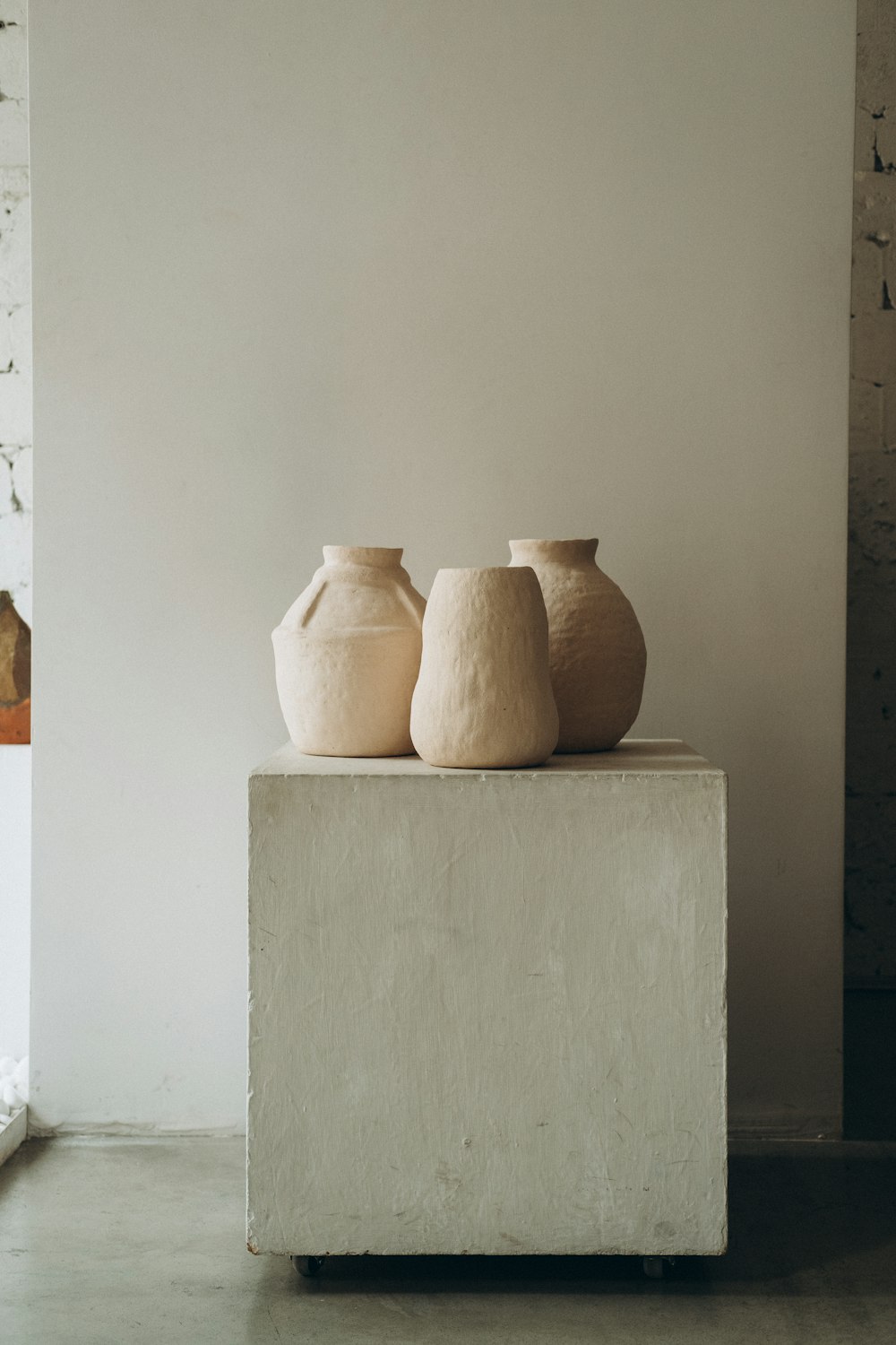 brown clay vase on white wooden shelf