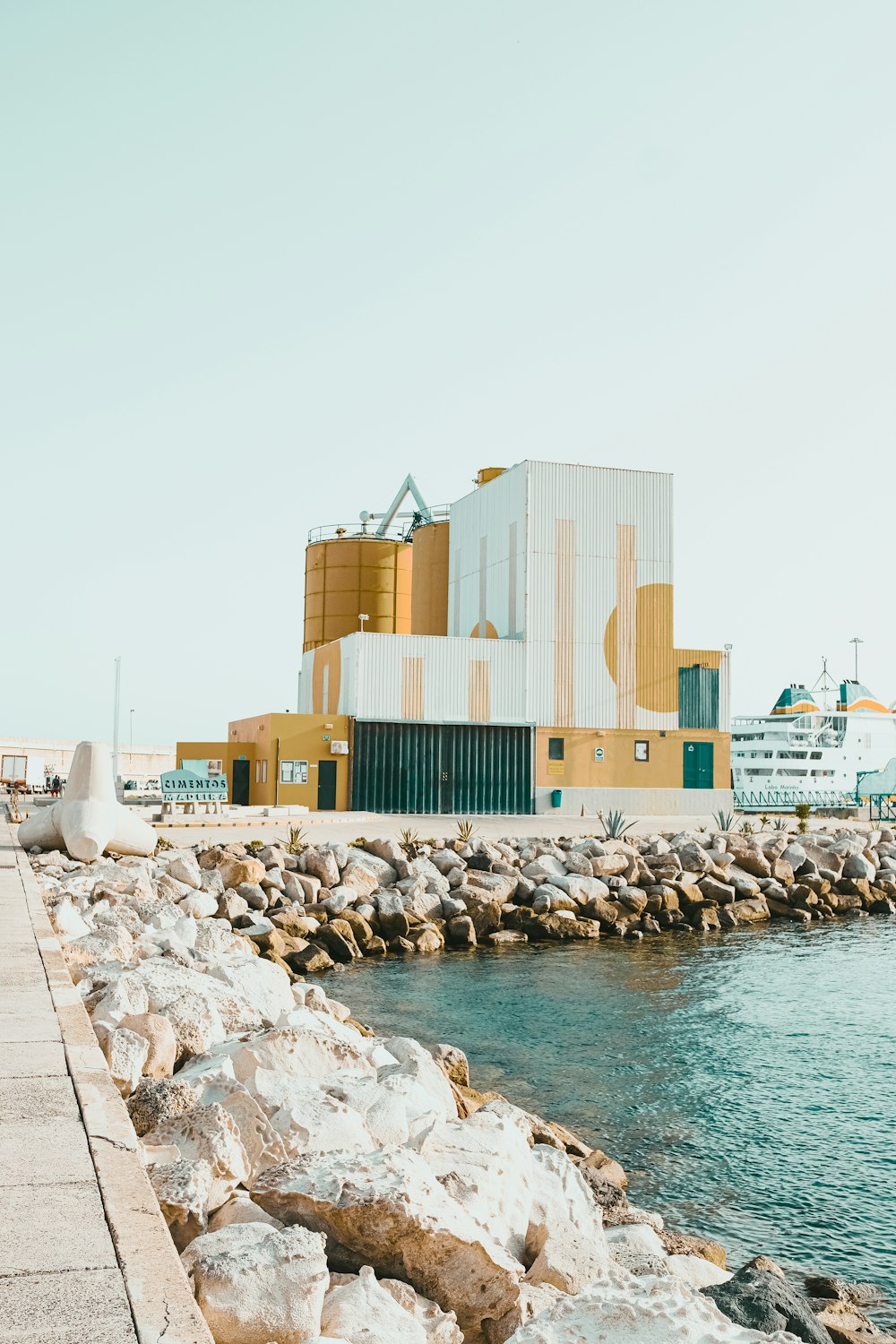 edificio in cemento marrone e bianco vicino allo specchio d'acqua durante il giorno