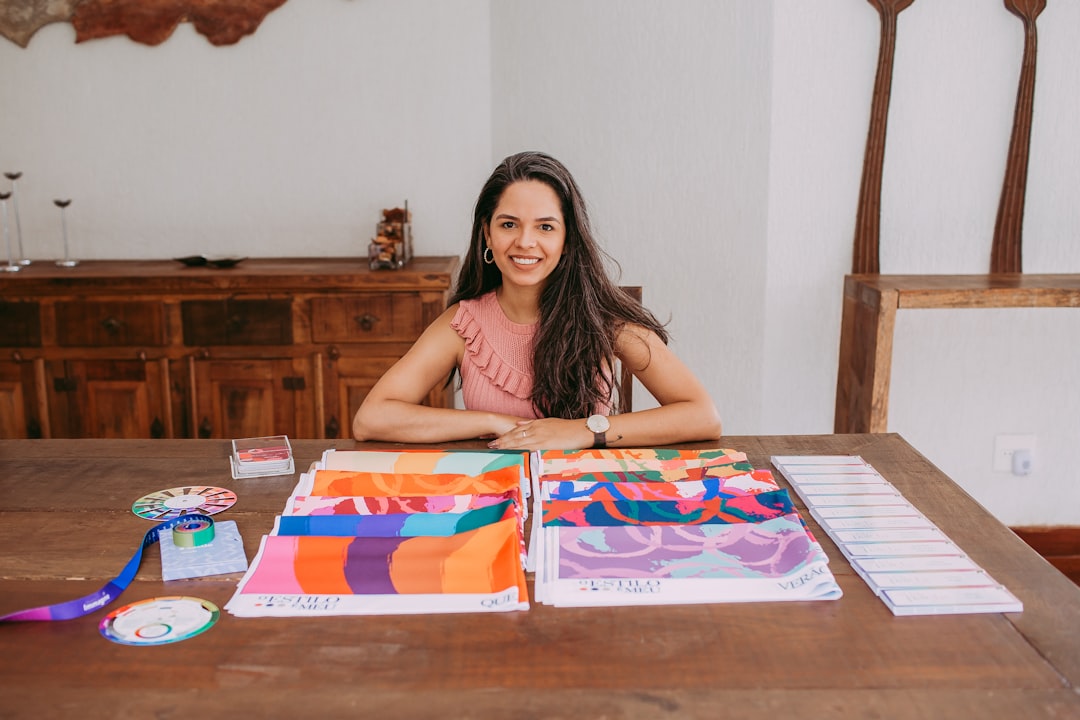 woman in white and black tank top sitting beside brown wooden table