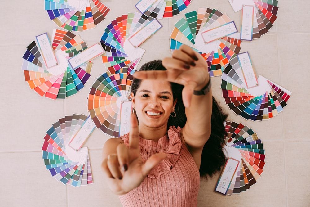 woman in pink sweater making peace sign