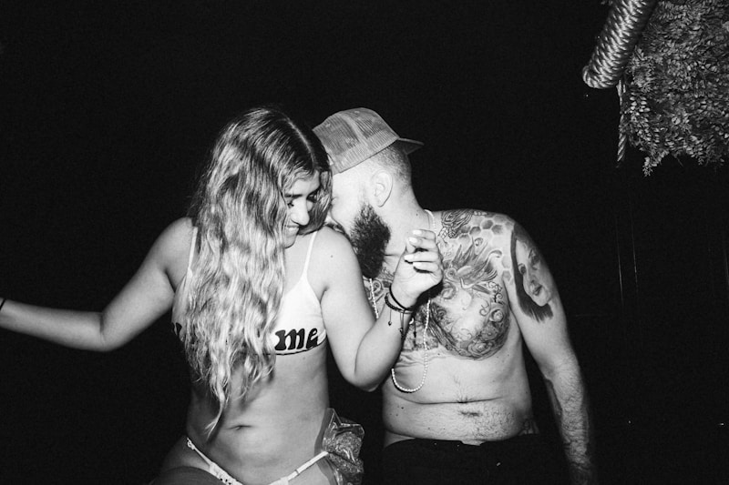 man and woman kissing grayscale photo