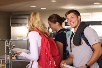 woman in red and white jacket beside man in gray crew neck t-shirt