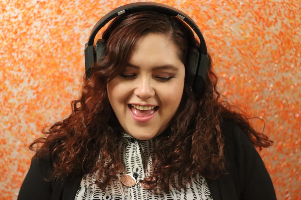 Mujer con camisa blanca y negra con auriculares negros