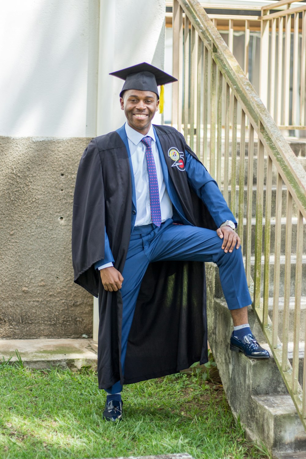 a man in a graduation gown sitting on a step