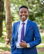 a man in a blue suit smiles for the camera