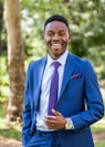 a man in a blue suit smiles for the camera