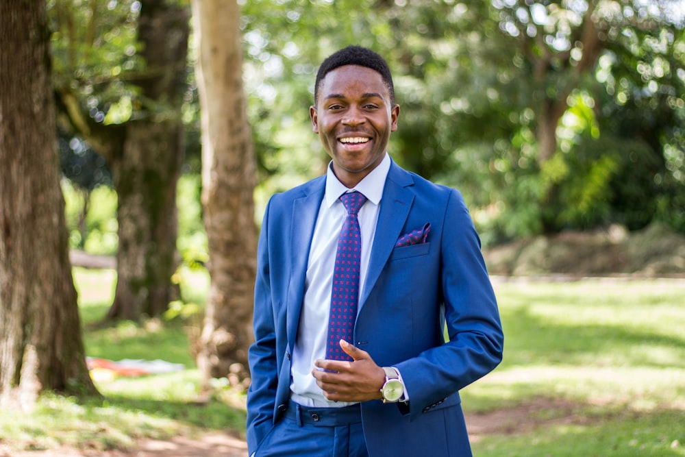 a man in a blue suit smiles for the camera