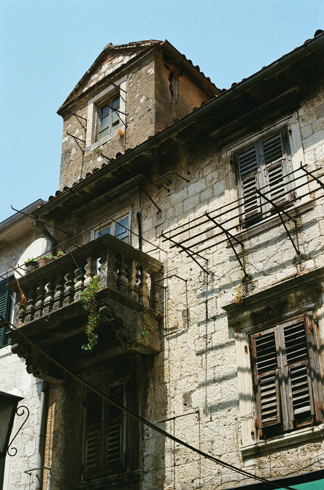 brown brick building with green plants on top