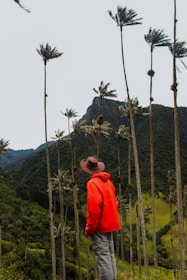 person in orange hoodie standing on green grass field during daytime