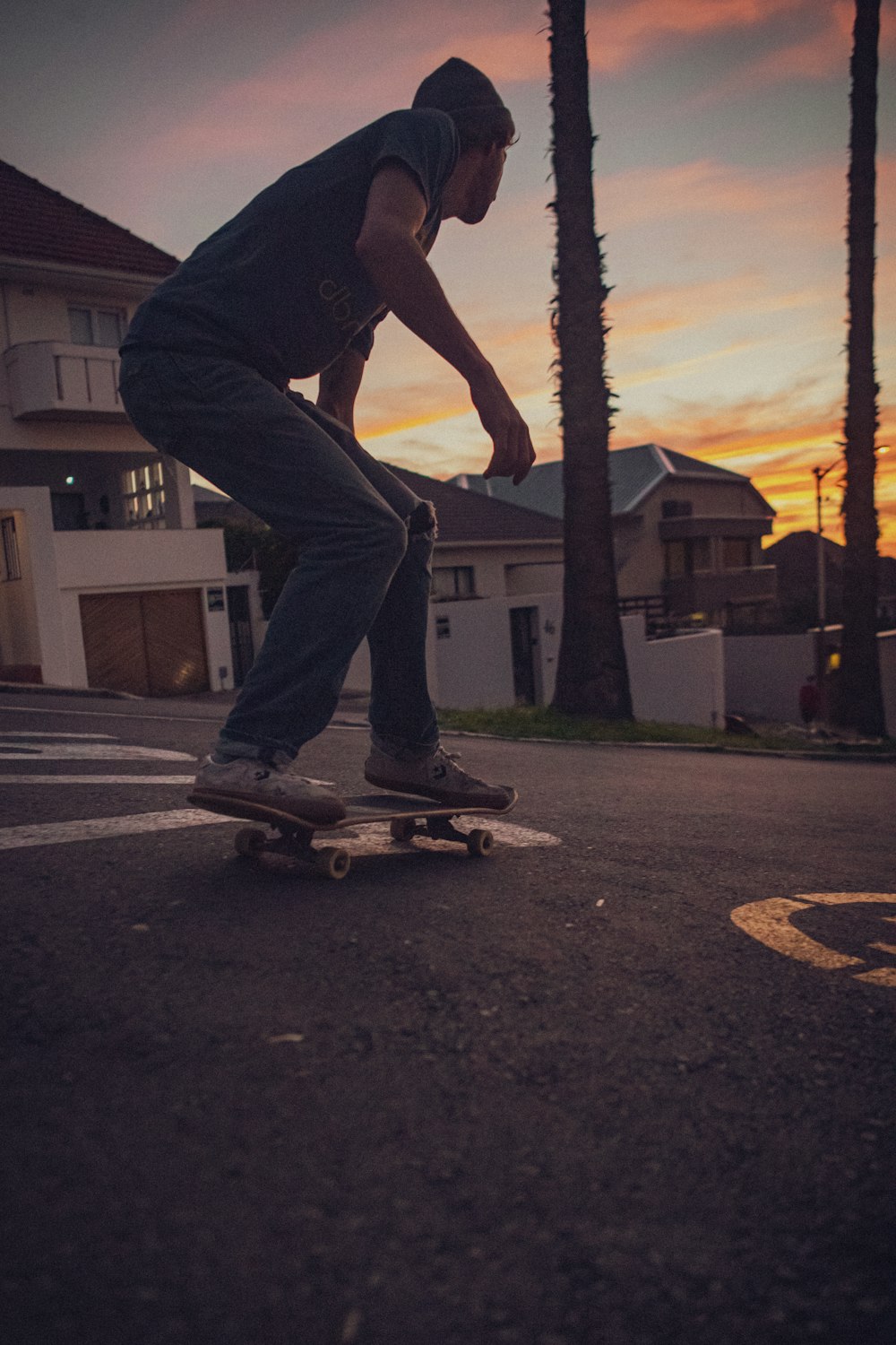 man in black t-shirt and blue denim jeans riding skateboard during daytime