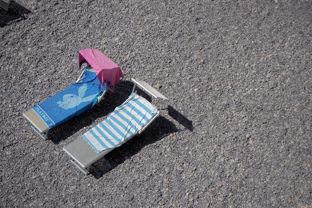 blue and white striped folding umbrella on gray sand