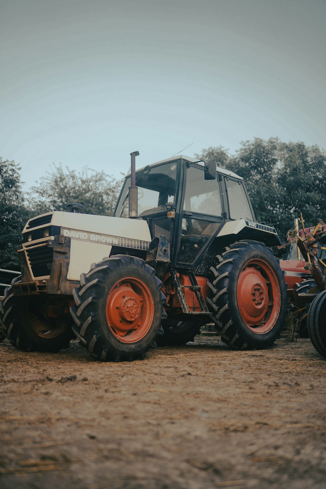 red and white tractor on brown field during daytime