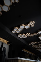 Elegant wooden ceiling light fixture in a modern space with black and white decor accents.