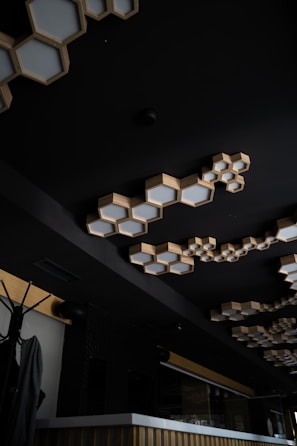 Elegant wooden ceiling light fixture in a modern space with black and white decor accents.