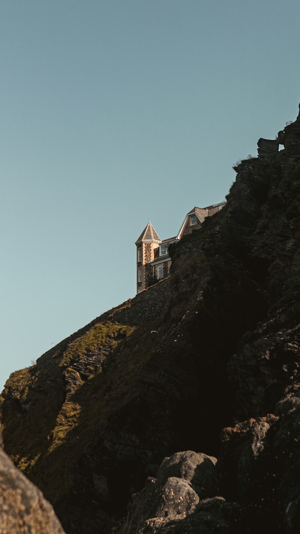 bâtiment en béton brun et blanc au sommet de la montagne pendant la journée