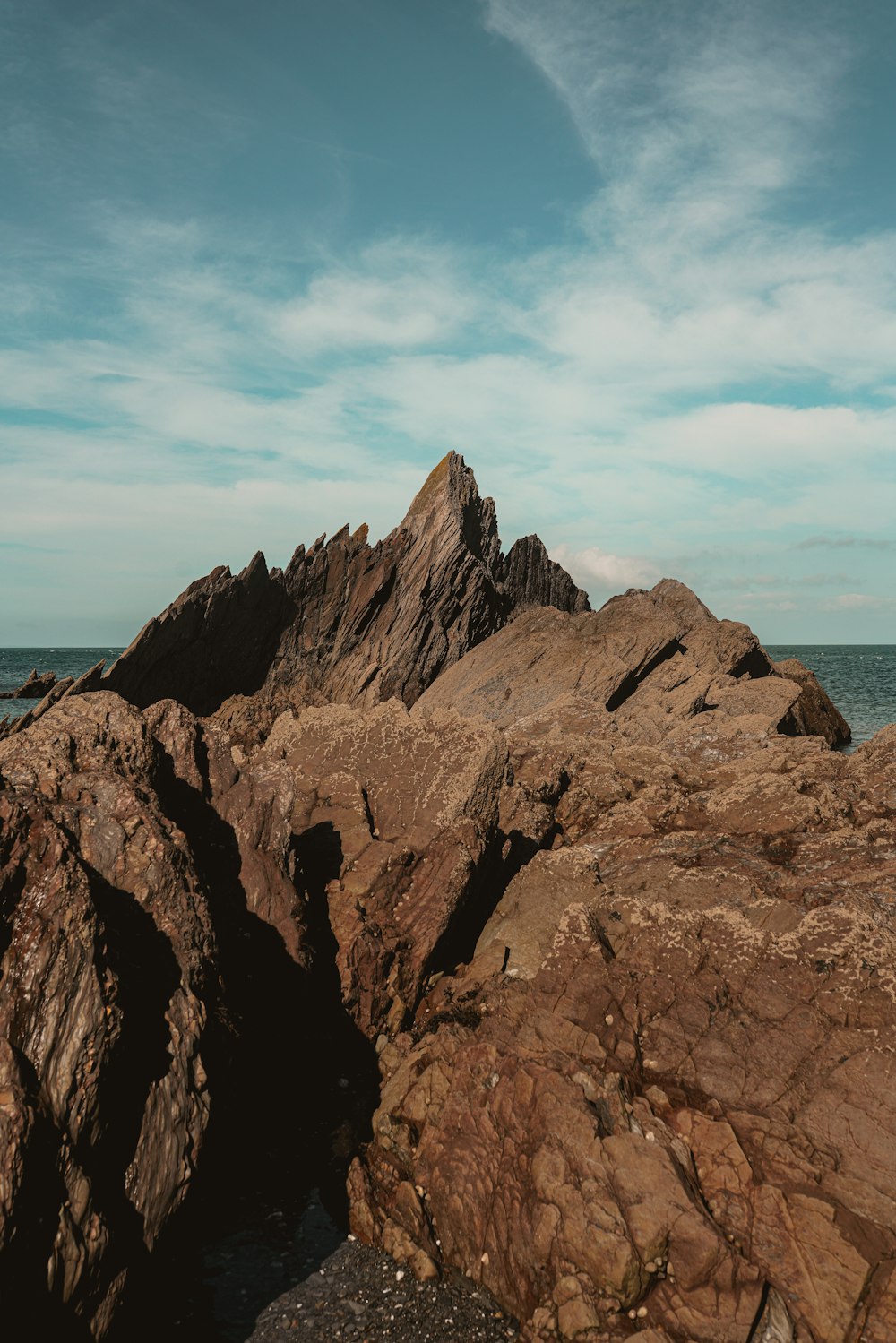 brown rock formation near body of water during daytime