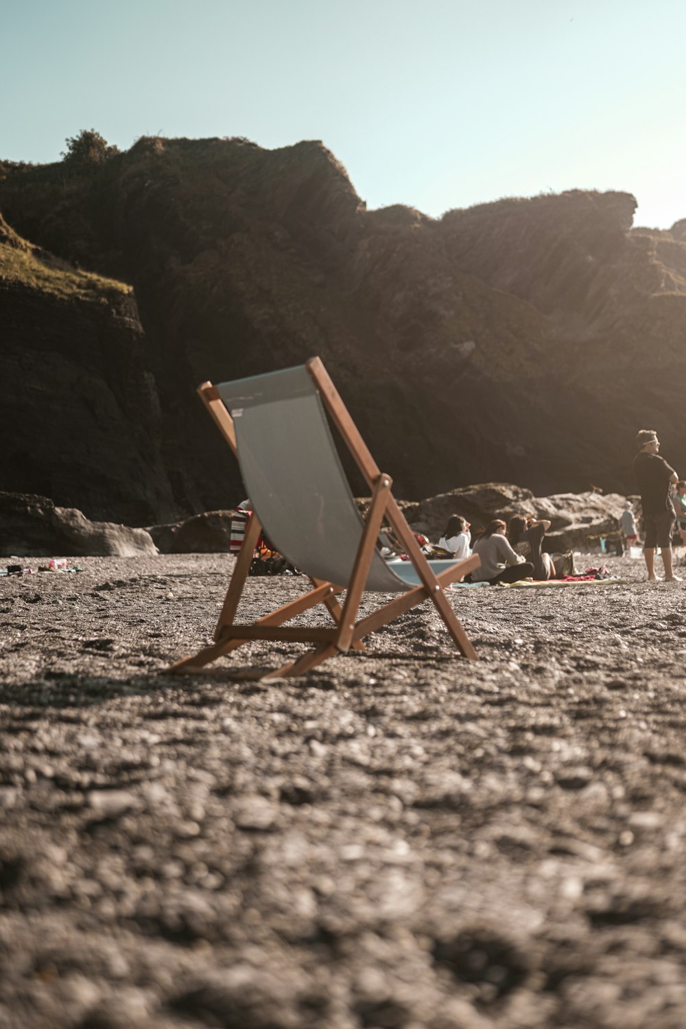 brown wooden folding chair on white sand during daytime