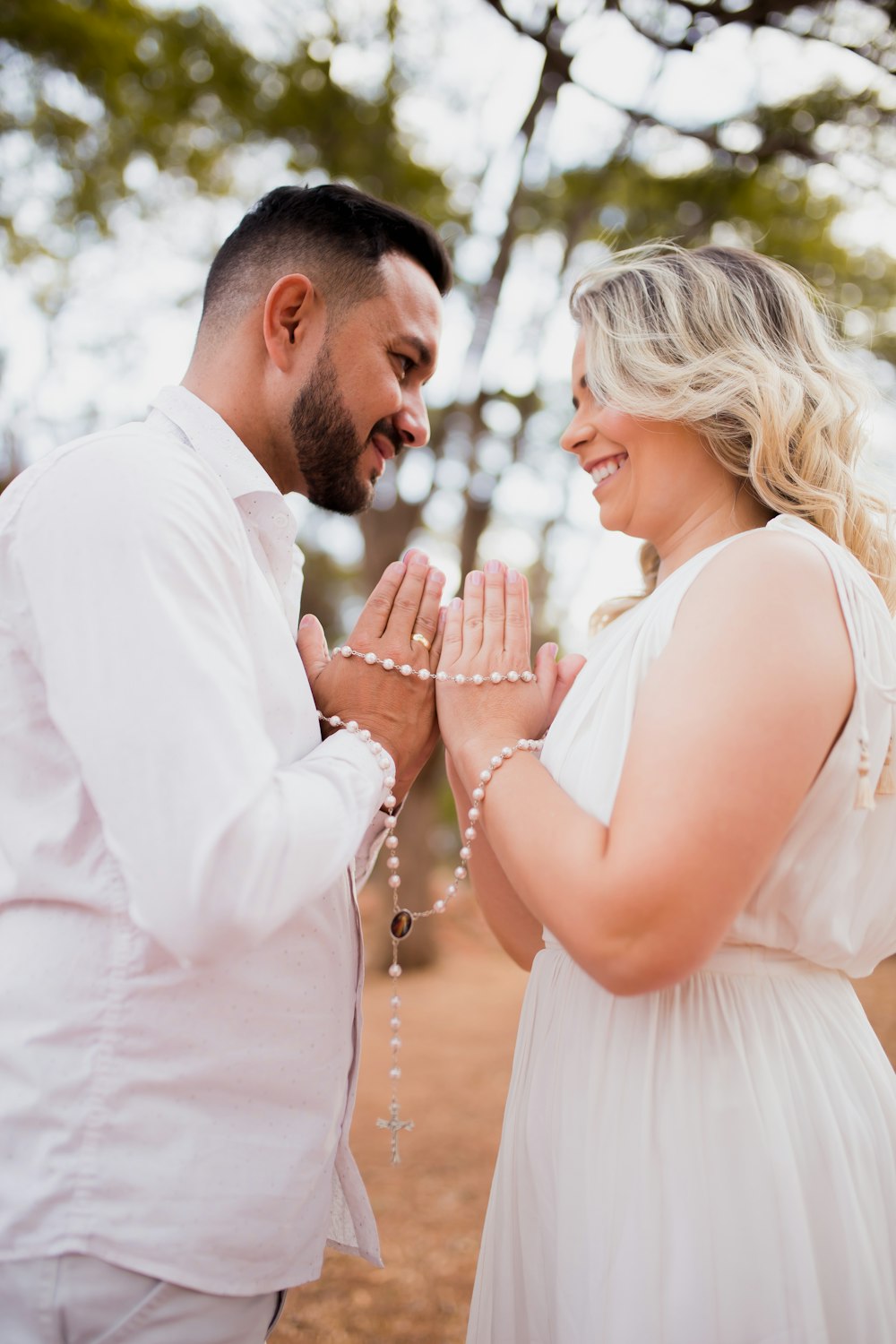 man in white dress shirt kissing woman in white dress during daytime