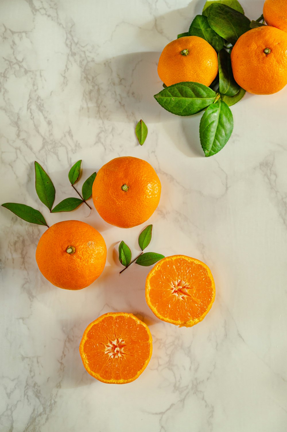 Frutos de naranja en rodajas sobre superficie blanca