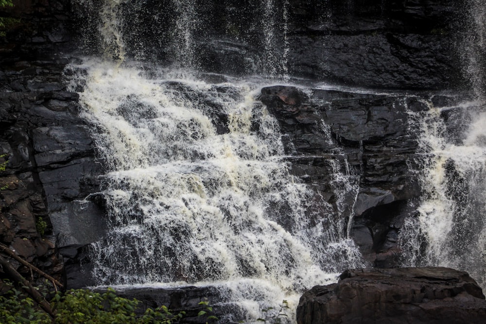 water falls on brown rocky mountain