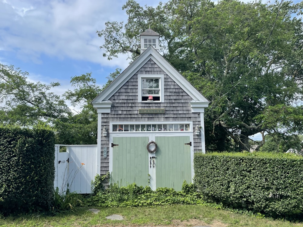 white wooden house surrounded by green trees under blue sky during daytime