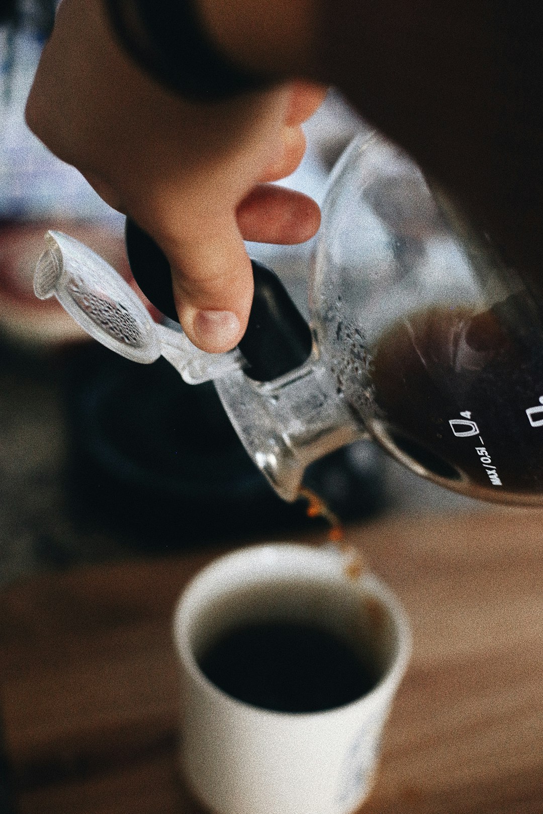 person holding clear glass mug