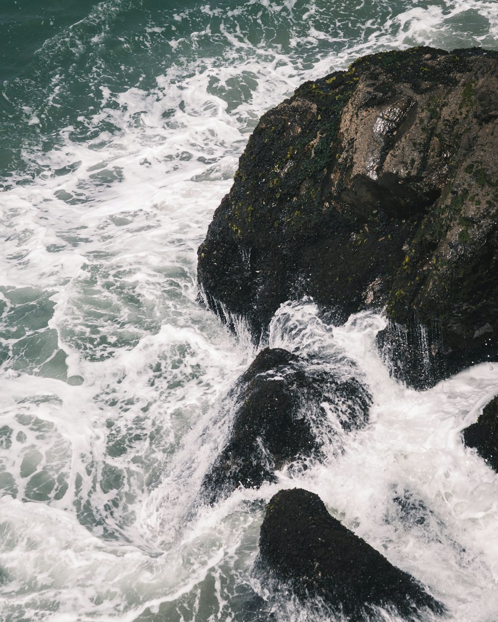 ocean waves crashing on rocky shore during daytime