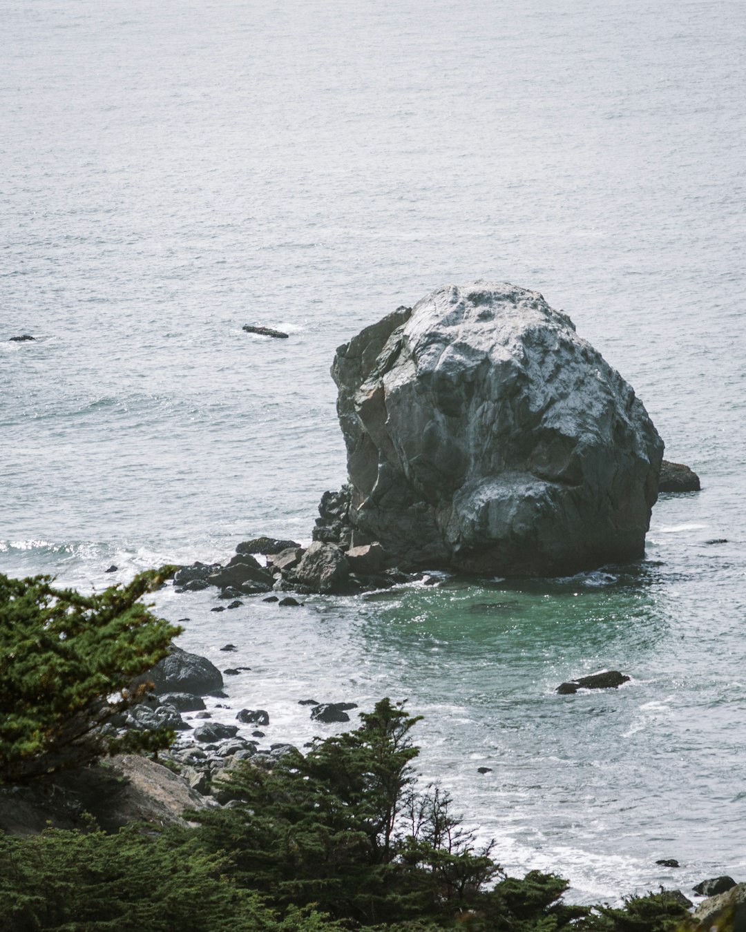 gray rock formation on body of water during daytime