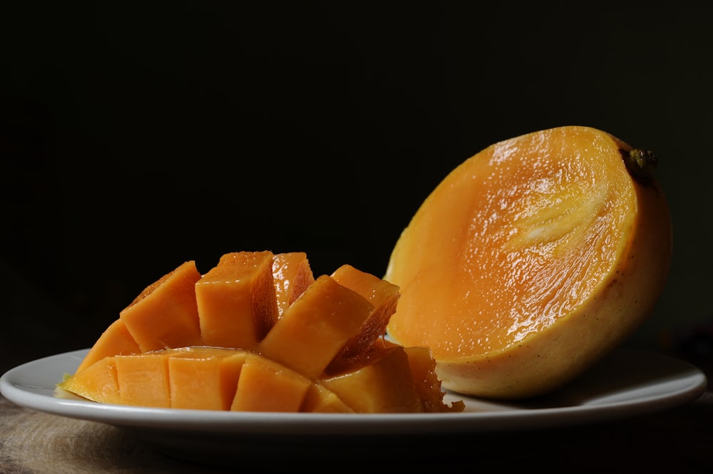 sliced orange fruit on black ceramic bowl