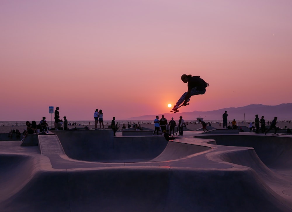 silhouette of people on a skateboard park during sunset