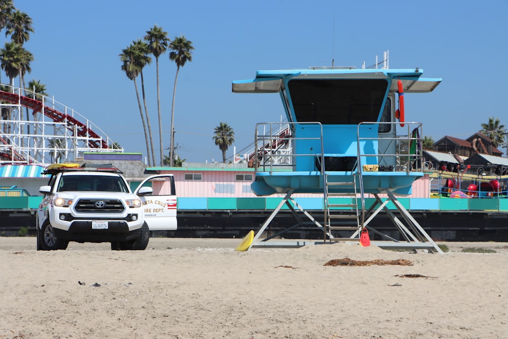 Casita de salvavidas de madera azul y blanca en la orilla de la playa durante el día