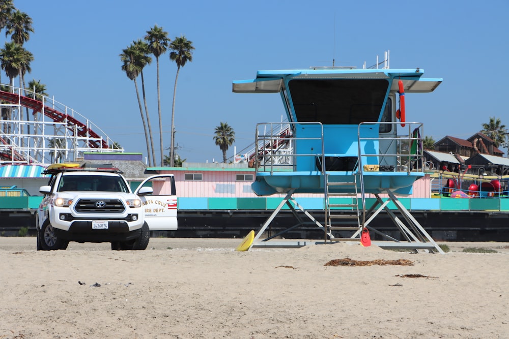 blue and white wooden lifeguard house on beach shore during daytime