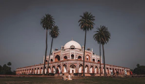 The serene gardens surrounding the Mausoleum of Mohammed V with intricate architecture.
