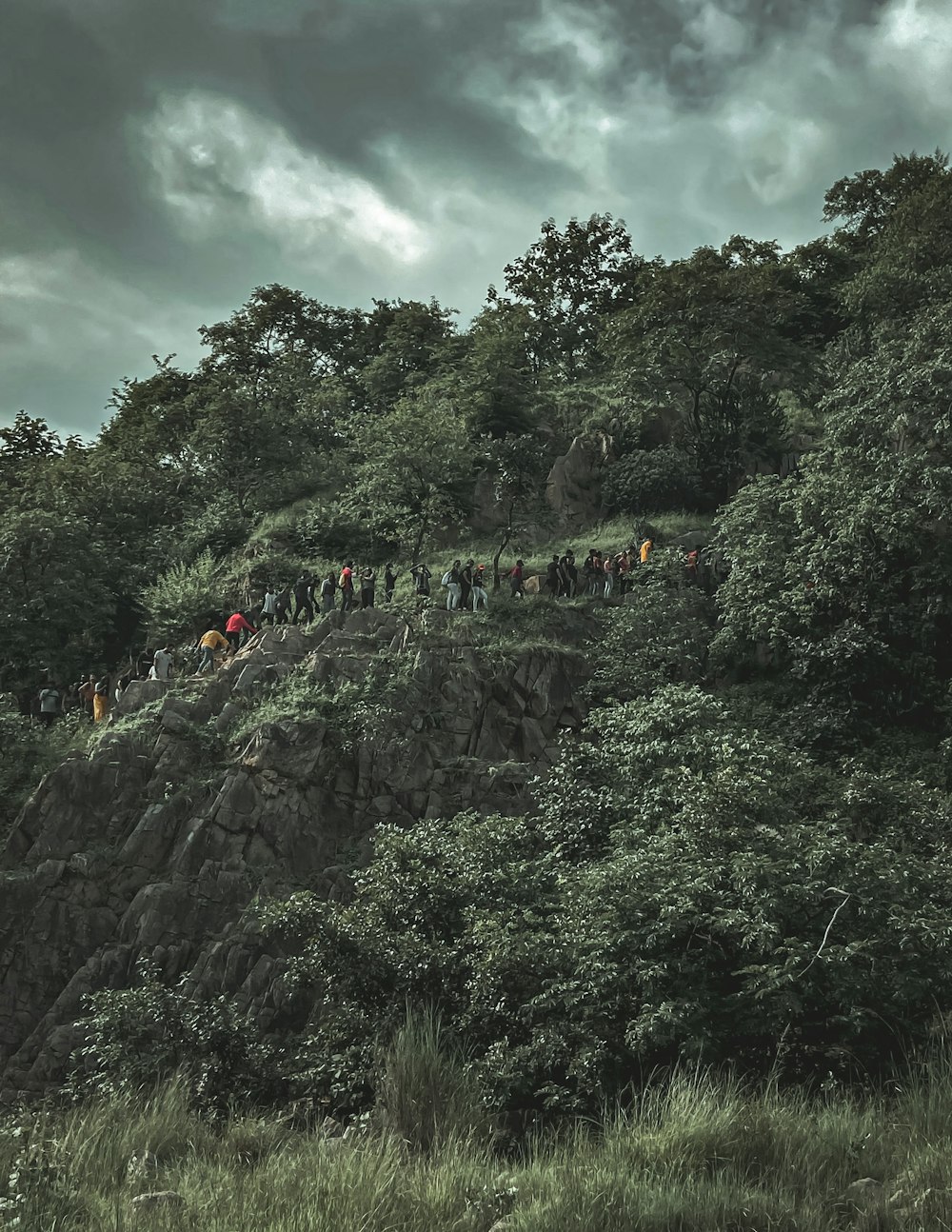 people on mountain under cloudy sky during daytime